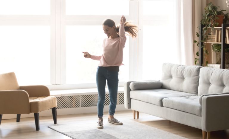 Woman happy dancing in living room